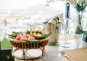 una cesta de comida y una botella de vino en una mesa en Hilltop Wellness Resort, en Phuket