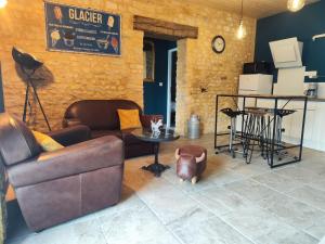 a living room with a couch and a table at La ferme aux chats in Formigny