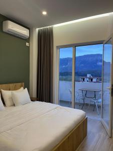 a bedroom with a bed and a balcony with a table at Patio Rooms Gjirokaster in Gjirokastër