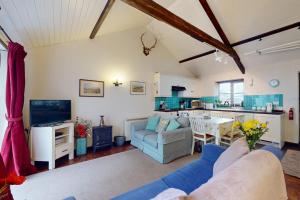 a living room with a couch and a kitchen at Draydon Cottage Dulverton in Dulverton