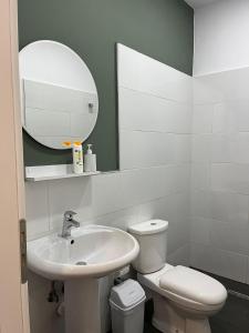 bagno con lavandino, servizi igienici e specchio di Patio Rooms Gjirokaster a Gjirokastër