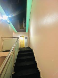 a hallway with stairs with a yellow door and a light at Eden Haven in Lagos