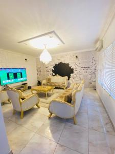 a living room with couches and a tv and a stone wall at Eden Haven in Lagos