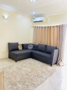 a living room with a blue couch in front of a window at Eden Haven in Lagos