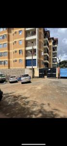 two cars parked in a parking lot in front of a building at Tawakal airbnb in Thika