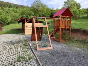 a playground with a slide and a play structure at Apartmán Bobo in Stožok