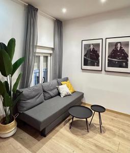 uma sala de estar com um sofá e duas mesas em Centric 1ºD em Madri