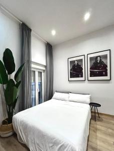 um quarto com uma grande cama branca e uma planta em Centric 1ºD em Madri
