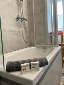 a bathtub with two signs on the edge of it at Moderne stilvolle Gästewohnung in Werdau
