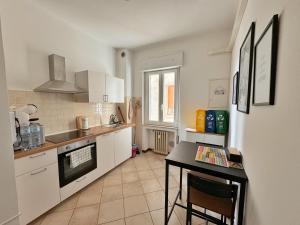 a kitchen with white cabinets and a table in it at BELLAVISTA , Bright and Stylish Two Bedroom Apartment in the Historic Center in Ravenna
