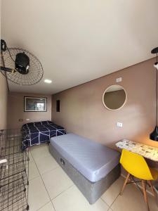 a bedroom with a bed and a desk and a fan at Kaleidoscopio Hostel in Sao Paulo