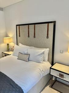 a bedroom with a bed with white sheets and pillows at Luxury Hidden Gem 2BDR APT In Mayfair in London