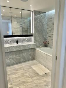 a bathroom with a tub and a sink and a mirror at Luxury Hidden Gem 2BDR APT In Mayfair in London