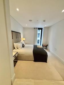 a bedroom with a large bed and a window at Luxury Hidden Gem 2BDR APT In Mayfair in London