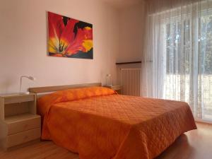 1 dormitorio con 1 cama con colcha de color naranja en Casa Belli Holiday Apartments Adults Only, en Arco