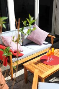 a couch on a patio with a table and two glasses at Deluxe-Apartment Altstadt in Ettlingen