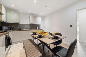 a kitchen with a table and chairs in a room at Luxury Unit Sleeps 5 Ensuite 2 bath Games FREE WI-FI LEICESTER CITY CENTRE in Leicester