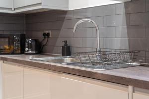 a kitchen counter with a sink and a faucet at Luxury Unit Sleeps 5 Ensuite 2 bath Games FREE WI-FI LEICESTER CITY CENTRE in Leicester