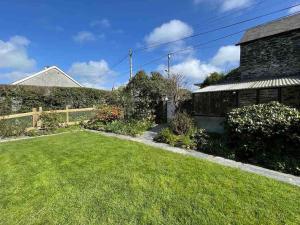 a yard with a house and a grass yard at The Hayloft - New Dog friendly with garden and parking in Port Isaac