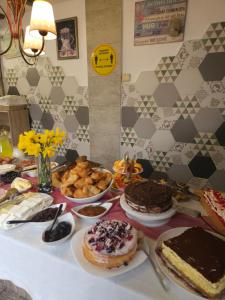 stół z ciastami i innym jedzeniem na nim w obiekcie Priyateli - Friends w mieście Wielkie Tyrnowo