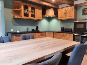a kitchen with a wooden table and blue chairs at Chez Lydie in Fellering