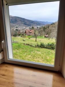 a window with a view of a field of grass at Chez Lydie in Fellering