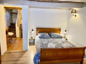 een slaapkamer met een bed met een houten hoofdeinde bij Les Volets Blancs in Dinan