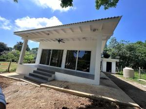 a small white house with a roof at Baquis Island Bungalow in Utila