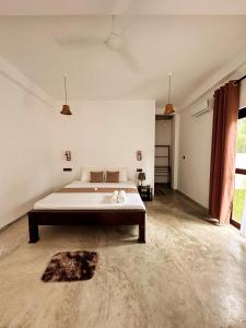 een slaapkamer met een groot bed in een witte kamer bij Linton Villa in Kalutara