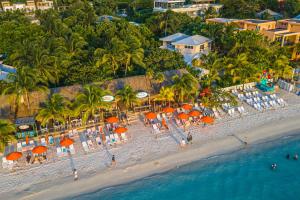 una vista aerea di una spiaggia con sedie e ombrelloni di Paradise Beach Hotel & Resort a West Bay