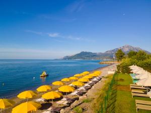 a row of umbrellas on a beach next to the water at Hotel Eden Park Cilento in Policastro Bussentino +19 photos