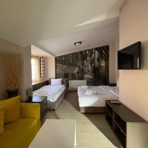 um quarto de hotel com duas camas e um sofá em Di Angolo Apartments em Ohrid