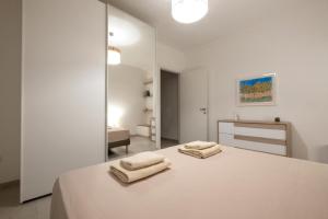 Un dormitorio blanco con dos toallas en una cama. en Casa Matilde, en Leverano 16 fotos más