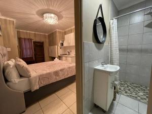 een slaapkamer met een bed en een badkamer met een wastafel bij DOMIN LUXURY SUITES in Kaapstad