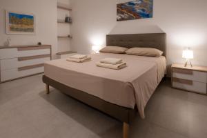 sypialnia z dużym łóżkiem z ręcznikami w obiekcie Casa Matilde w mieście Leverano