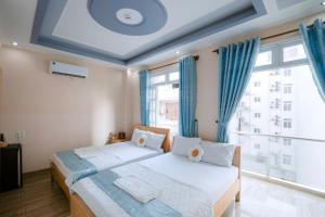 1 Schlafzimmer mit 2 Betten und einem großen Fenster in der Unterkunft Calido Hotel Vung Tau in Xã Thang Tam