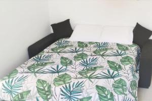 a bed with a green and white comforter on it at 2p bas de Villa avec Jacuzzi privatif proche de Nice in Saint-Laurent-du-Var