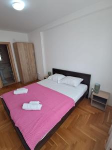 a bedroom with a large bed with two towels on it at Belveder Montenegro in Rafailovici