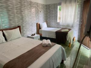 a hotel room with two beds and a chair at Multiverso Hostel in Lençóis