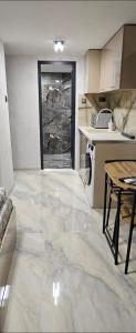 eine Küche mit Marmorboden und einem Tisch in der Unterkunft нов модерен ! Studio Apartment Dreams 2! in Sliven