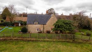 een huis met een speeltuin ervoor bij Bird's Cottage in Kettering