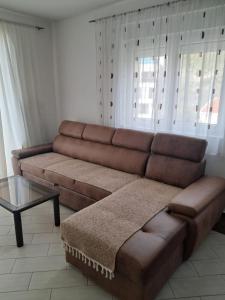 ein braunes Sofa im Wohnzimmer mit einem Tisch in der Unterkunft Belveder Montenegro in Rafailovici