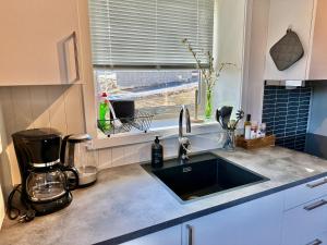 encimera de cocina con fregadero y ventana en Leknes Airport Apartment, en Leknes