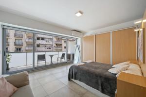 1 dormitorio con cama y ventana grande en La Vie Recoleta en Buenos Aires