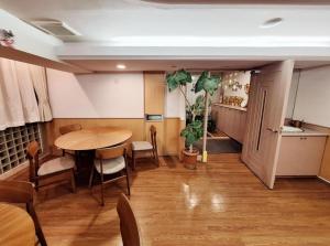Hotel Yuni -Comfortable stay Star-Club iD في طوكيو: غرفة طعام مع طاولة وكراسي