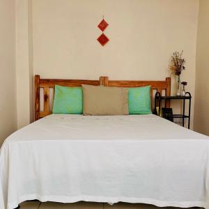 a bedroom with a white bed with blue pillows at Multiverso Hostel in Lençóis