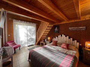 ein Schlafzimmer mit einem großen Bett und einer Treppe in der Unterkunft Villa Herbert, Chambres d'Hôtes et Gîte in Andernos-les-Bains