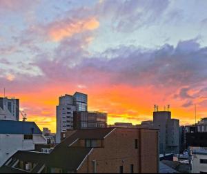 um horizonte da cidade com um pôr-do-sol ao fundo em Hotel Yuni -Comfortable stay Star-Club iD em Tóquio