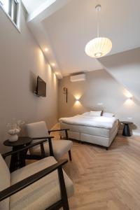 1 dormitorio con cama, sofá y mesa en SAYŌ Boutique Hotel en Scheveningen