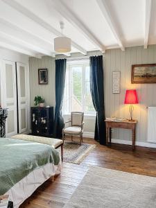um quarto com uma cama, uma cadeira e uma janela em LA FERME DE NEHOU em Gatteville-le-Phare
